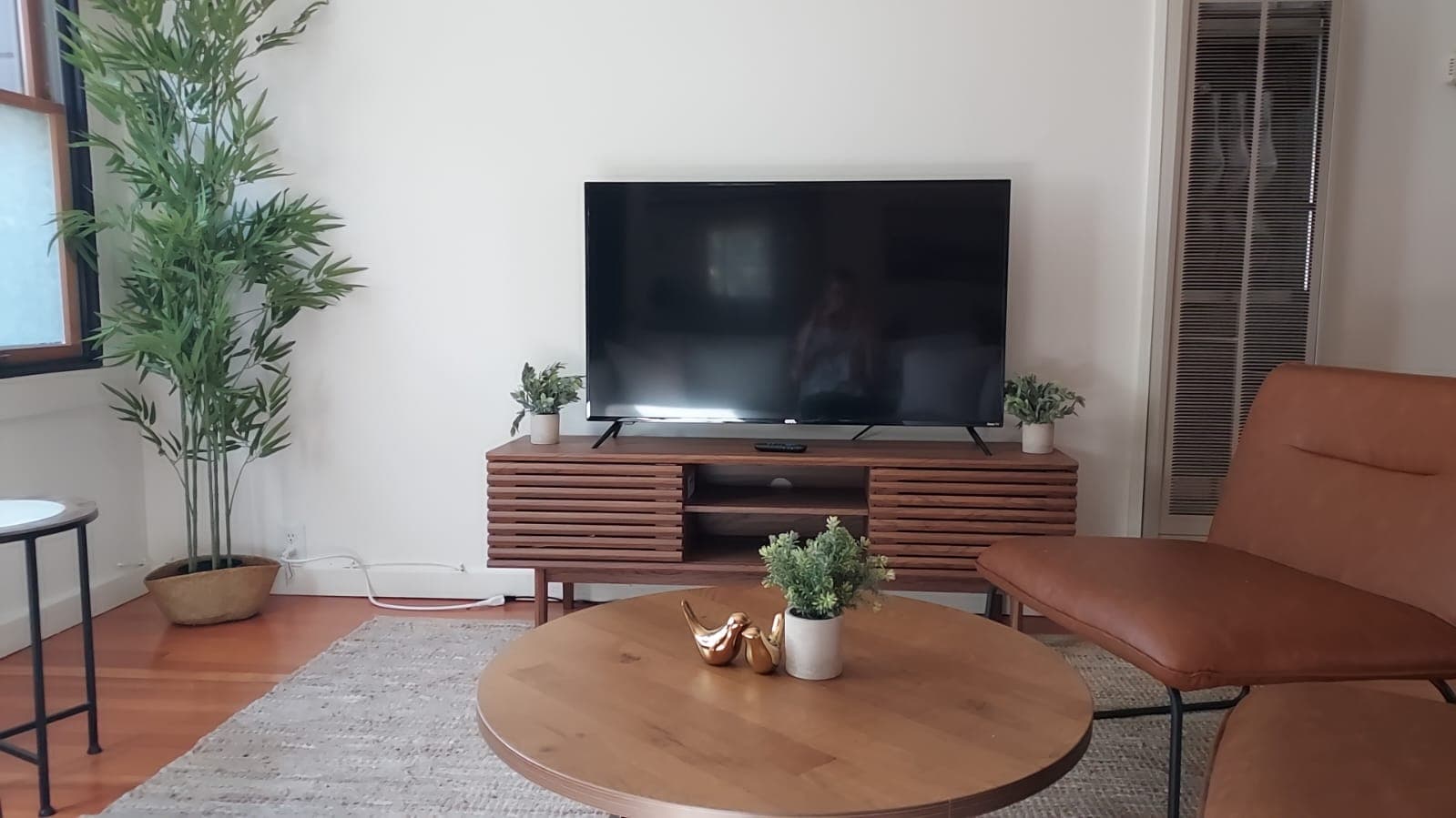 Inviting living room with a large flat-screen TV, cozy seating, and modern decor for relaxing after a day of exploring.