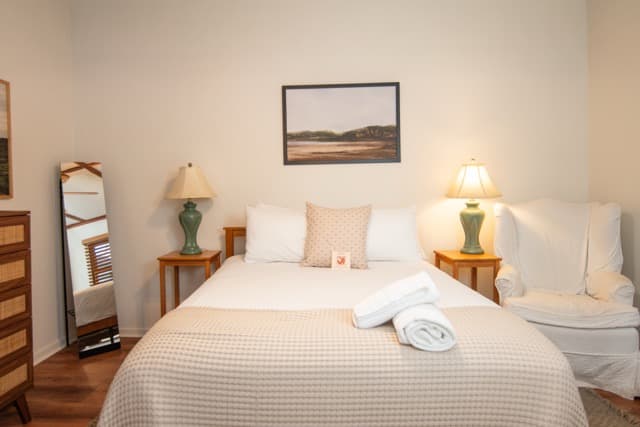 Cozy bedroom with plush bedding, warm wood accents, and modern comforts for a relaxing wine country stay.