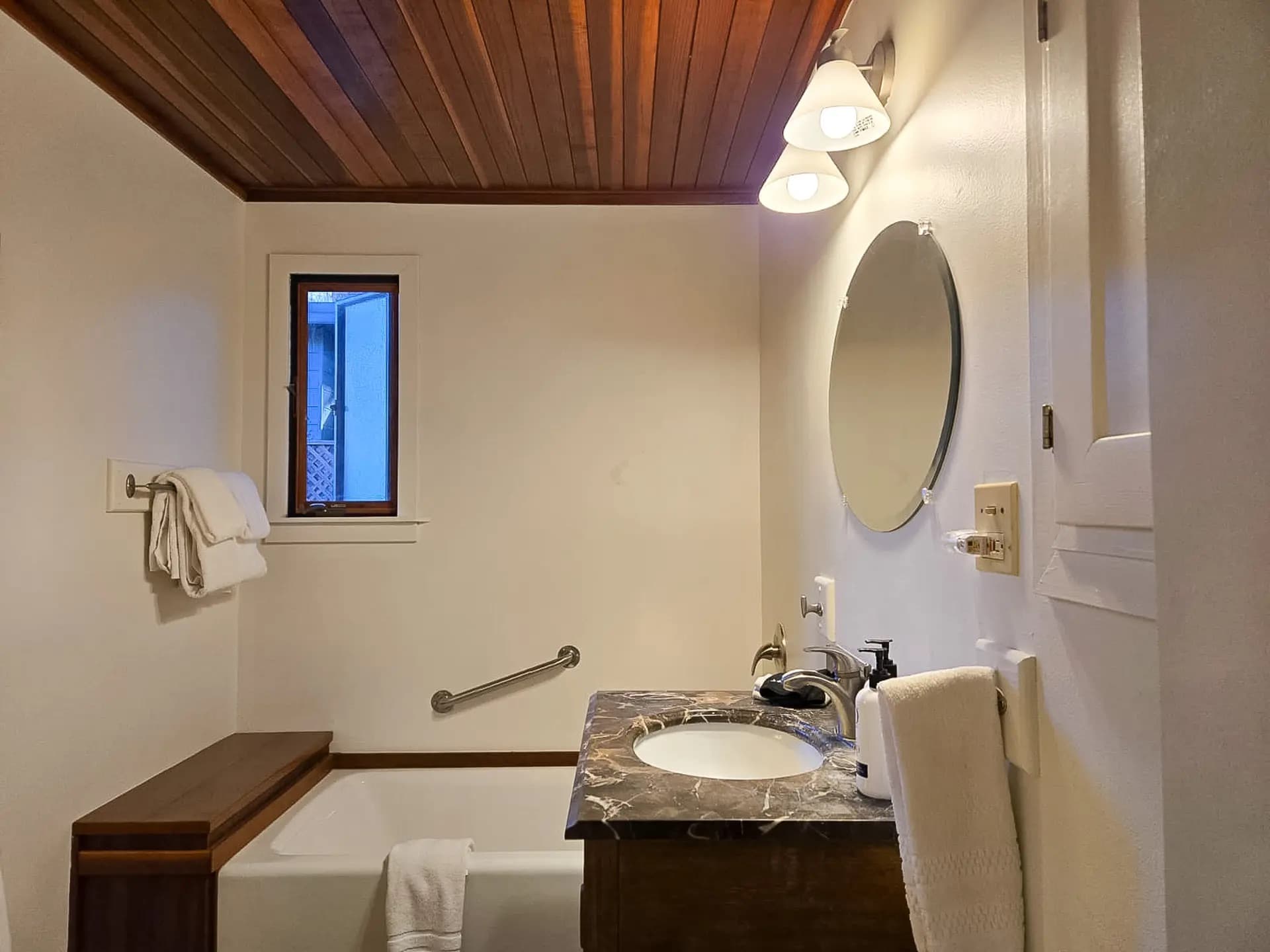 Spacious bathroom with a soaking tub, modern vanity, and warm wood accents for a relaxing retreat experience.
