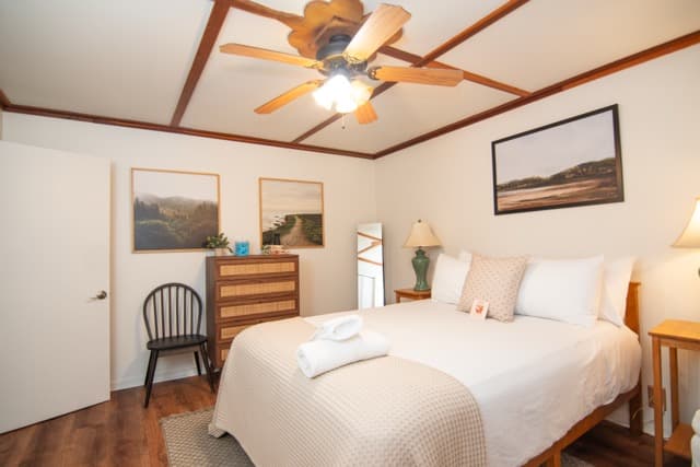 Bright and inviting bedroom featuring comfortable seating, soft lighting, and stylish decor for the perfect coastal retreat.